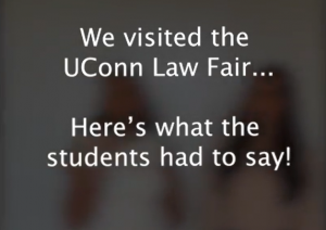 A dark gray blurred image of two students with white text that says "We visited the UConn Law Fair... Here's what the students had to say!